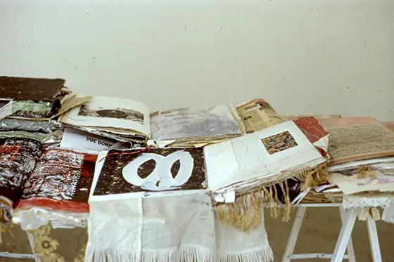 Handmade books stacked and opened on trestle tables.