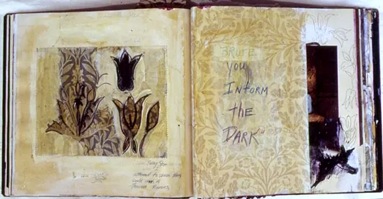 An open book with a tulip drawing on a gold-toned page.