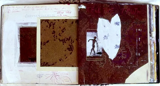 An open book with a collage of dark fabric and a small photograph.