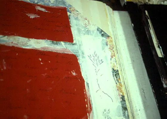 An open book with a large red painted page and a white border.