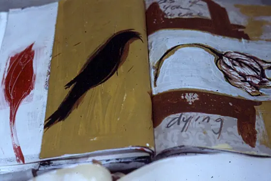 A page with a red leaf and a black bird painted on ochre.