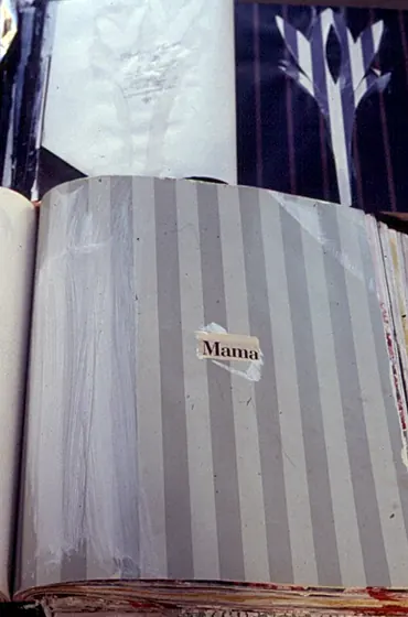 A grey-striped book with a small label reading Mama.